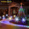 Outdoor holiday decor featuring a lighted Christmas tree and ground-level solar fireworks lights illuminating a pathway.