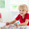 A smiling toddler is playing with a wooden magnetic color sorting maze board for counting and number skills.