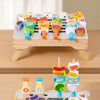 A wooden BBQ tripod playset for kids featuring various food items and accessories.