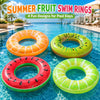 Four colorful fruit-themed swim rings floating in clear blue water.