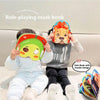 A child is wearing a playful orange and yellow animal mask dress-up set while sitting on a couch.