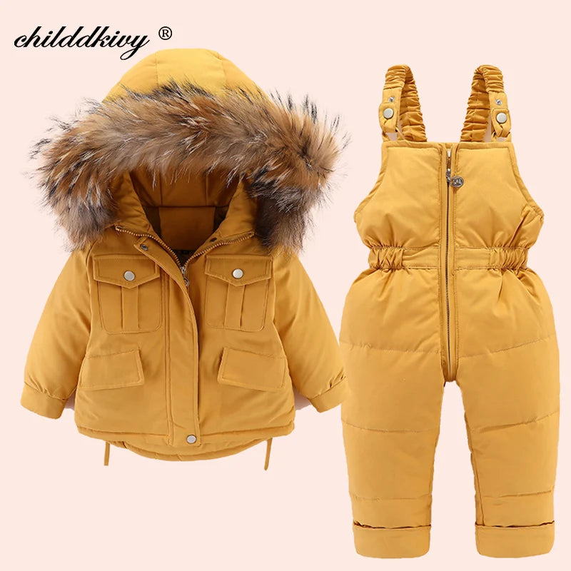 A mustard yellow baby winter down jacket and pants set with a faux fur hood.