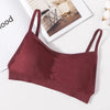 A maroon seamless U-back bralette with removable pads lying on a white surface.