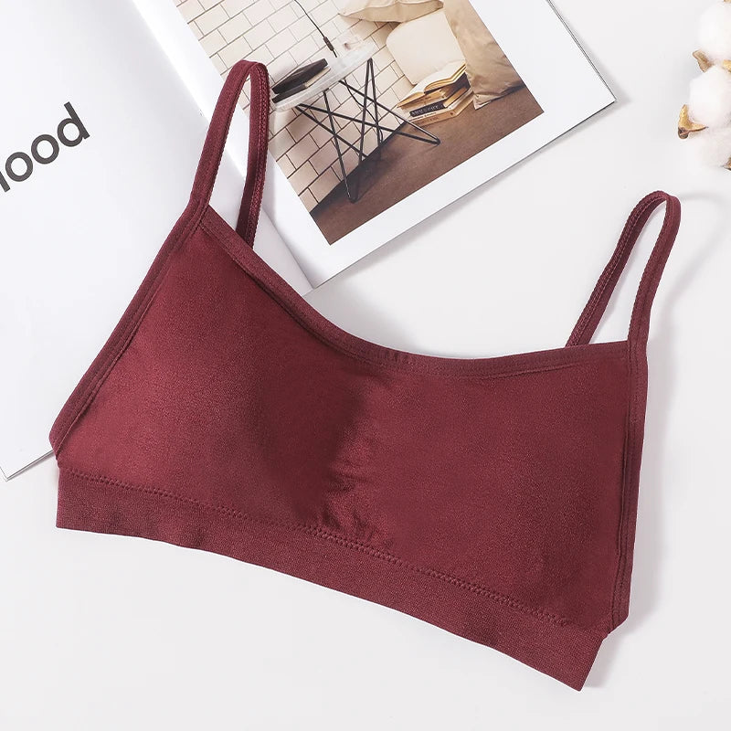 A maroon seamless U-back bralette with removable pads lying on a white surface.