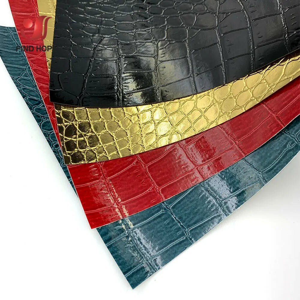 A stack of faux leather fabric strips in various colors including black, gold, red, and blue crocodile patterns.