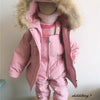 A pink baby winter down jacket and pants set with a faux fur hood displayed on a mannequin.