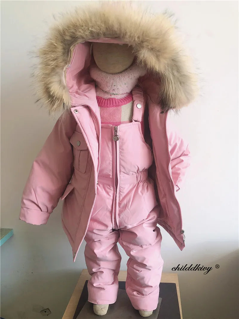 A pink baby winter down jacket and pants set with a faux fur hood displayed on a mannequin.