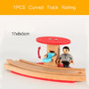 A single piece of curved track railing made of wood and red plastic is shown with a miniature train model.
