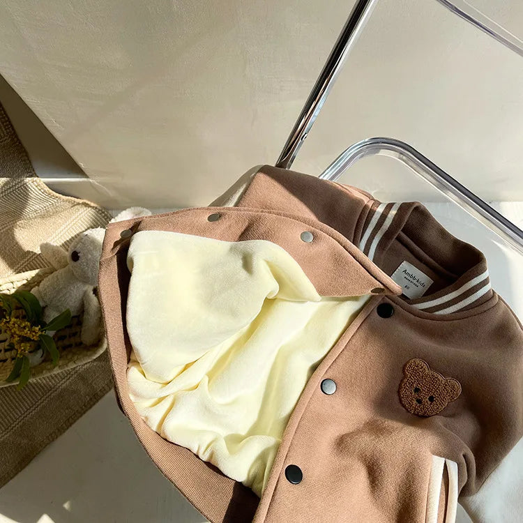 A tan corduroy jacket with light yellow fleece lining and brown buttons is displayed on a white surface.