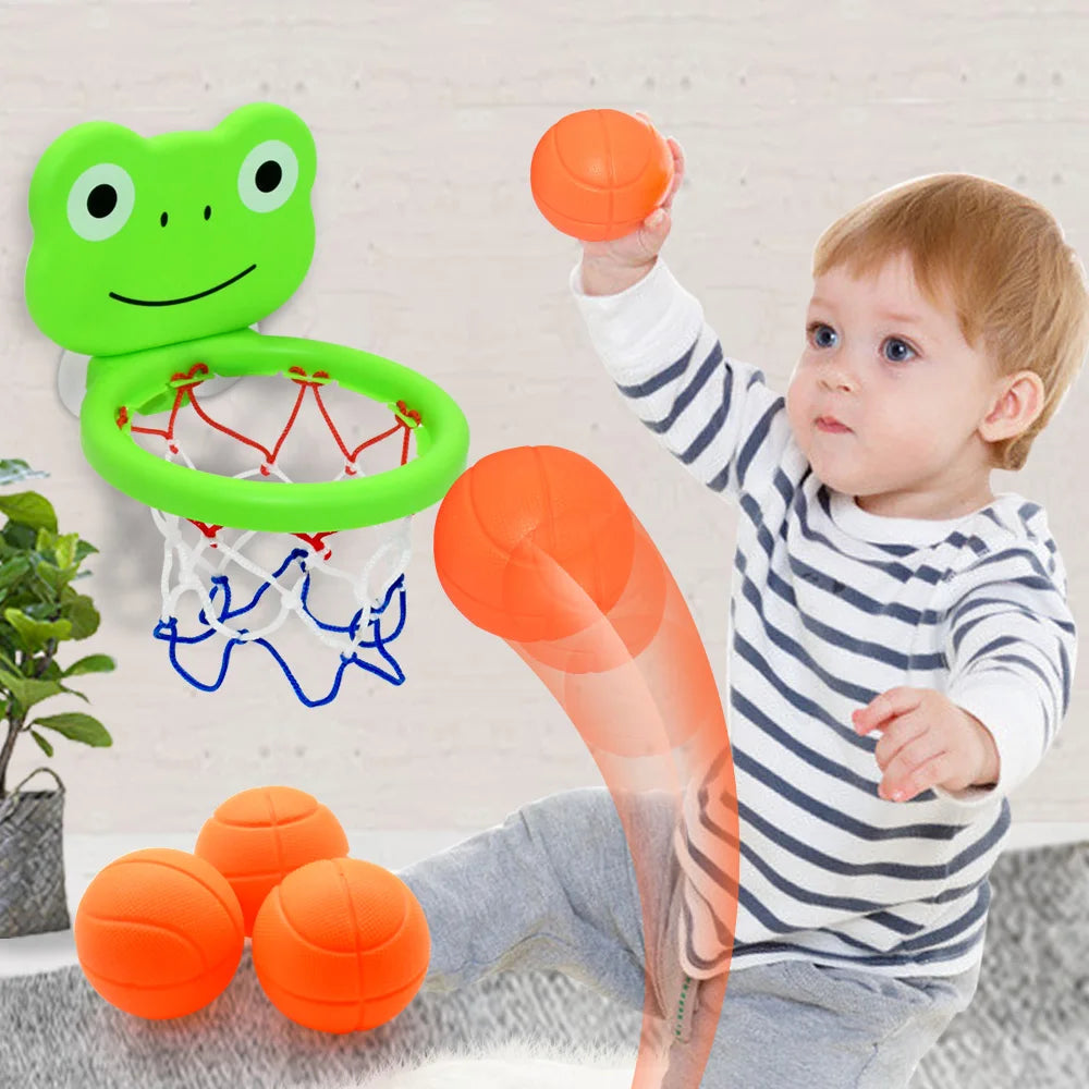 Et småbarn leker med en oransje basketballkurv og et grønt froskformet lekesett.