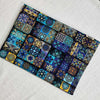 A square piece of bohemian mandala cotton fabric featuring intricate geometric patterns in shades of blue, purple, and gold.