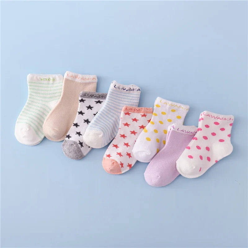 A set of ten striped cotton baby socks in various pastel colors and patterns laid out on a light blue background.