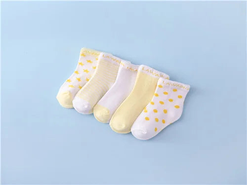 A set of five yellow and white striped cotton baby socks laid out on a light blue background.