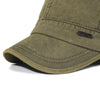 A close-up of a olive green flat cap with a stitched logo on the brim.