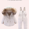A white baby winter down jacket and pants set with a faux fur hood displayed flat.
