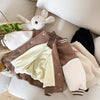 A brown corduroy jacket with cream lining is displayed on a light surface next to a stuffed animal.