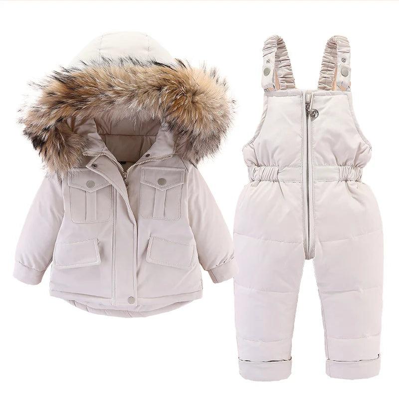 A white baby winter down jacket and pants set with a faux fur hood displayed on a white background.