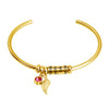 Gold bracelet featuring a family name charm, a leaf charm, and a pink birthstone.