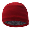 A solid red knitted winter beanie hat with a gray faux fur lining.