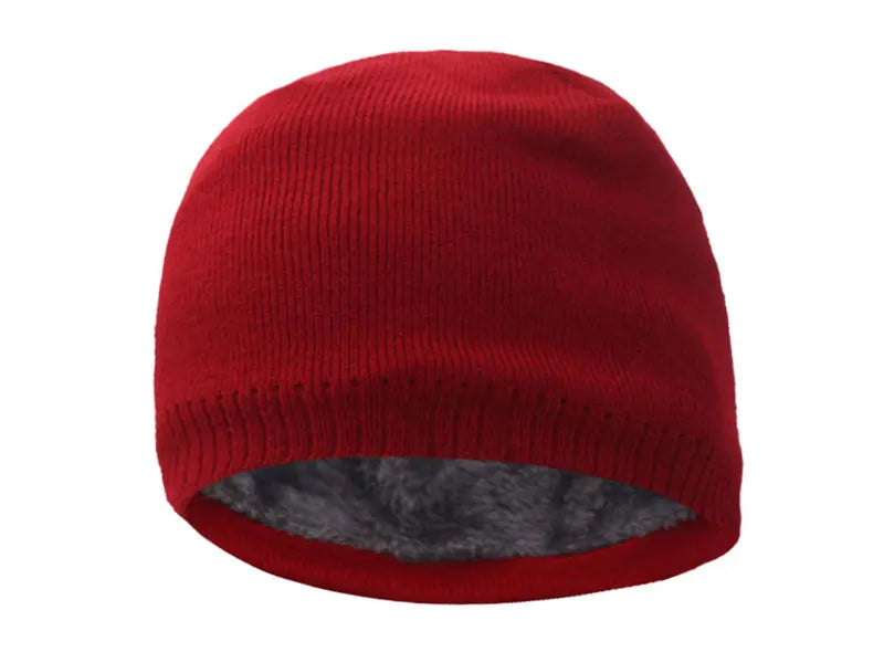 A solid red knitted winter beanie hat with a gray faux fur lining.