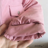A close-up of a pink baby winter down jacket sleeve and cuff, showing the fabric texture and stitching.