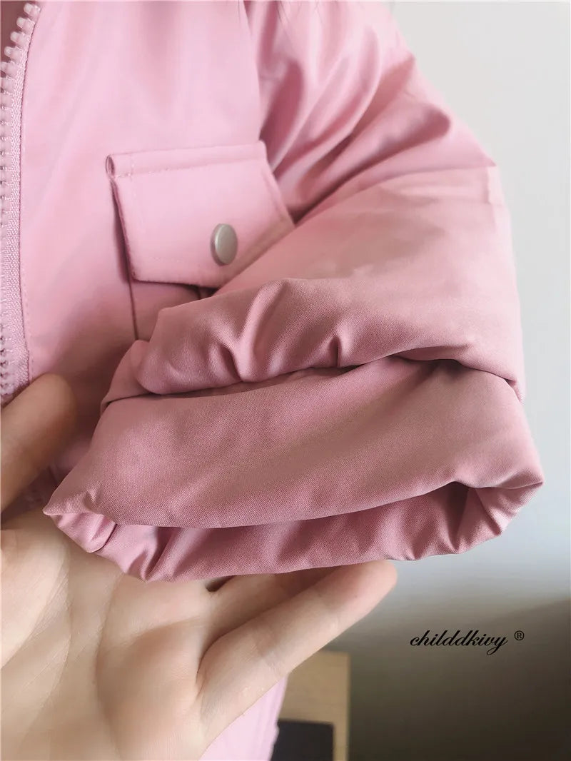 A close-up of a pink baby winter down jacket sleeve and cuff, showing the fabric texture and stitching.