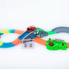 A glowing magnetic race track set featuring ramps, bridges, and a red vehicle on an orange and green track.