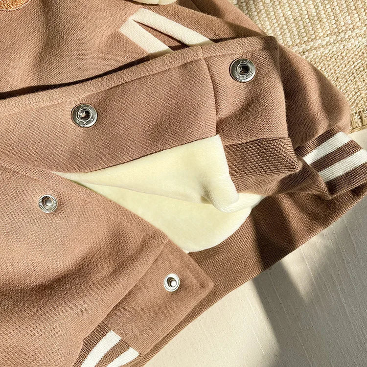 A close-up of a tan corduroy jacket with white stripes and fleece lining.