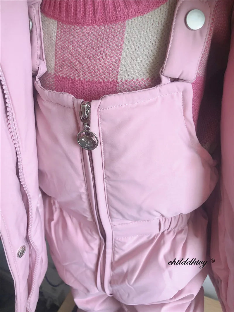 A pink baby winter down jacket and pants set with a faux fur hood displayed on a mannequin.