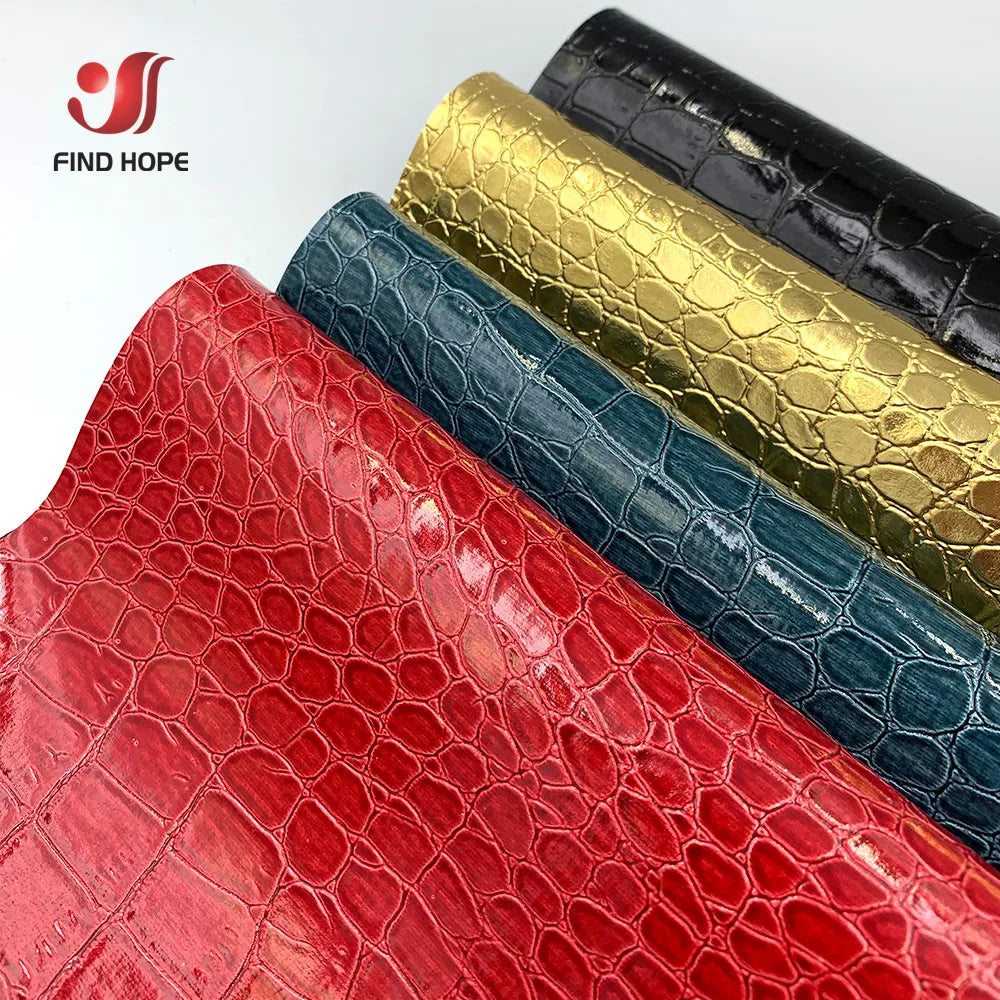 A close-up of various crocodile pattern faux leather fabrics in red, blue, and gold colors.