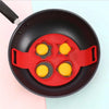 Rødt non-stick silikonsett med ringer for steking av pannekaker og egg i en mørk panne.