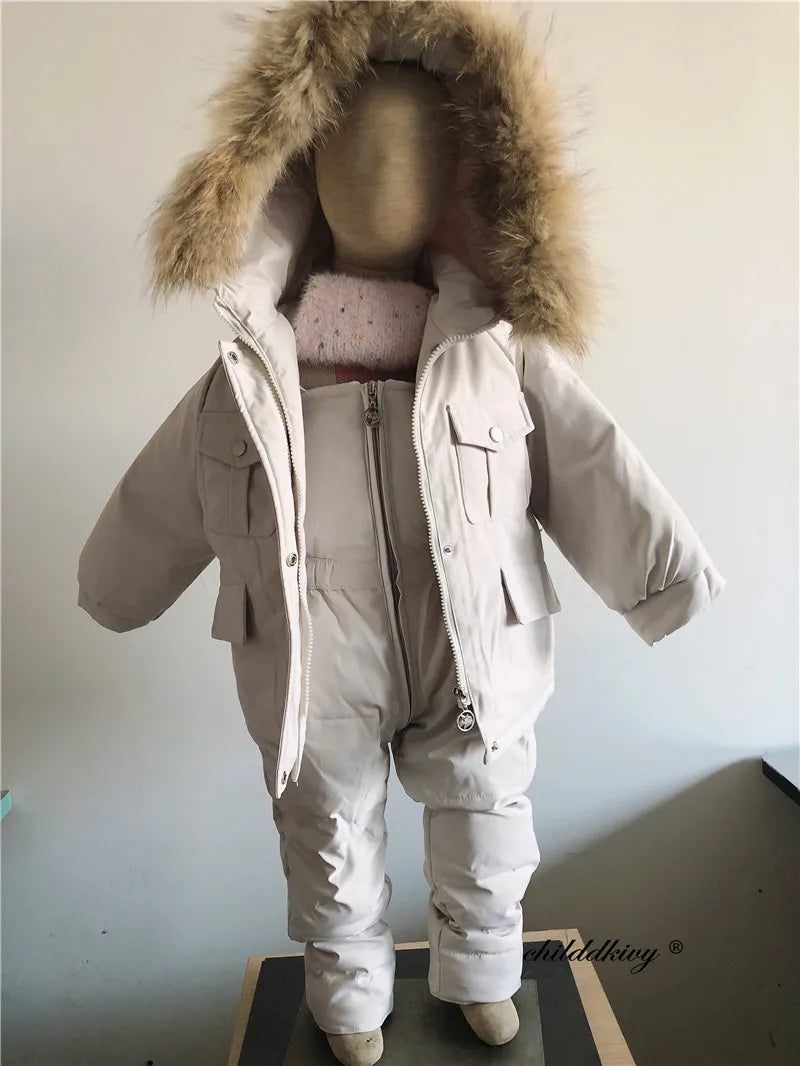 A beige baby winter down jacket and pants set with a faux fur hood displayed on a mannequin.