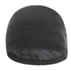 A dark gray knitted winter beanie hat with a fuzzy trim.