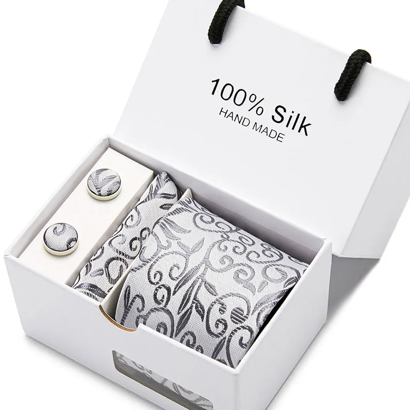 Una caja blanca con una corbata de seda jacquard azul marino con estampado de cachemira.