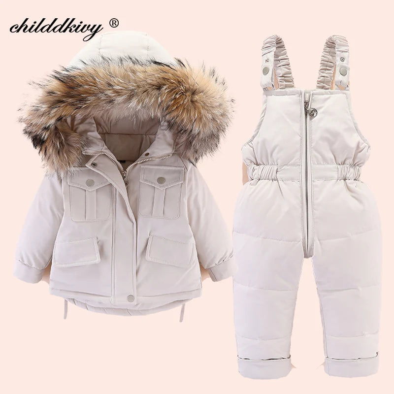 A white baby winter down jacket and pants set with a faux fur hood displayed on a light background.