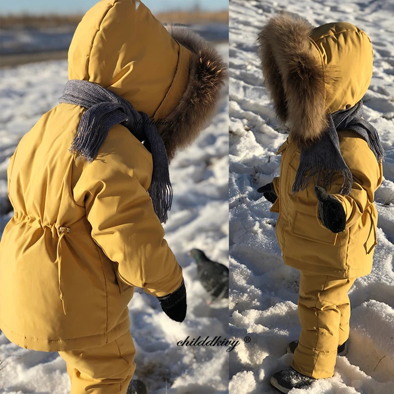 A yellow baby winter down jacket and pants set with a faux fur hood shown from the back.