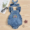 A denim romper for baby girls featuring rainbow embroidery and a matching headband, laid on a wooden surface.