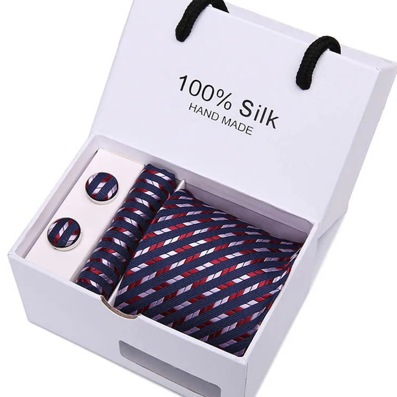 Una caja blanca con una corbata de seda azul marino hecha a mano con estampado de cachemira.