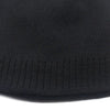 A close-up view of a black knitted beanie hat with ribbed texture.