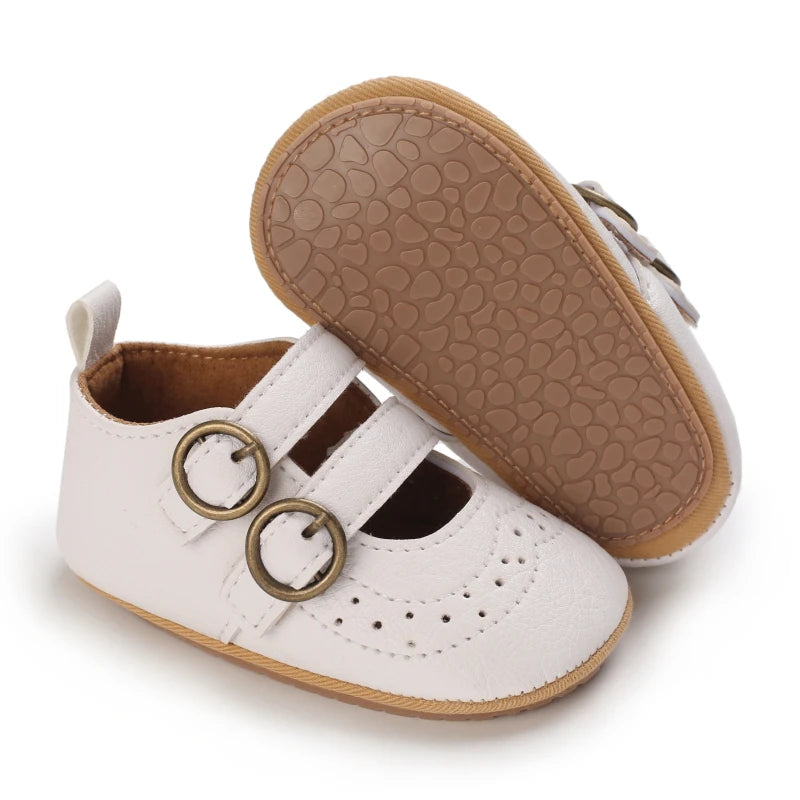A pair of white soft non-slip baby first walker shoes with tan rubber soles.