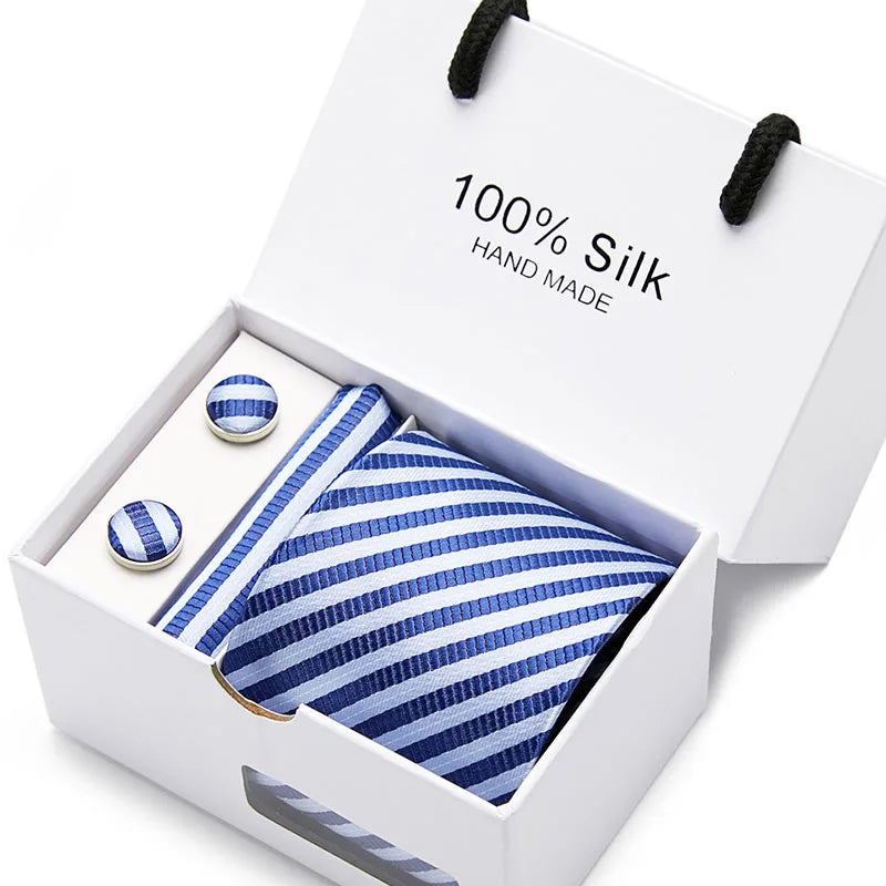 Una caja blanca con un cojín de seda azul marino a rayas hecho a mano y una corbata.