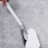 A hand is holding a white golf-style silicone toilet brush with a self-opening holder against a gray marble surface.