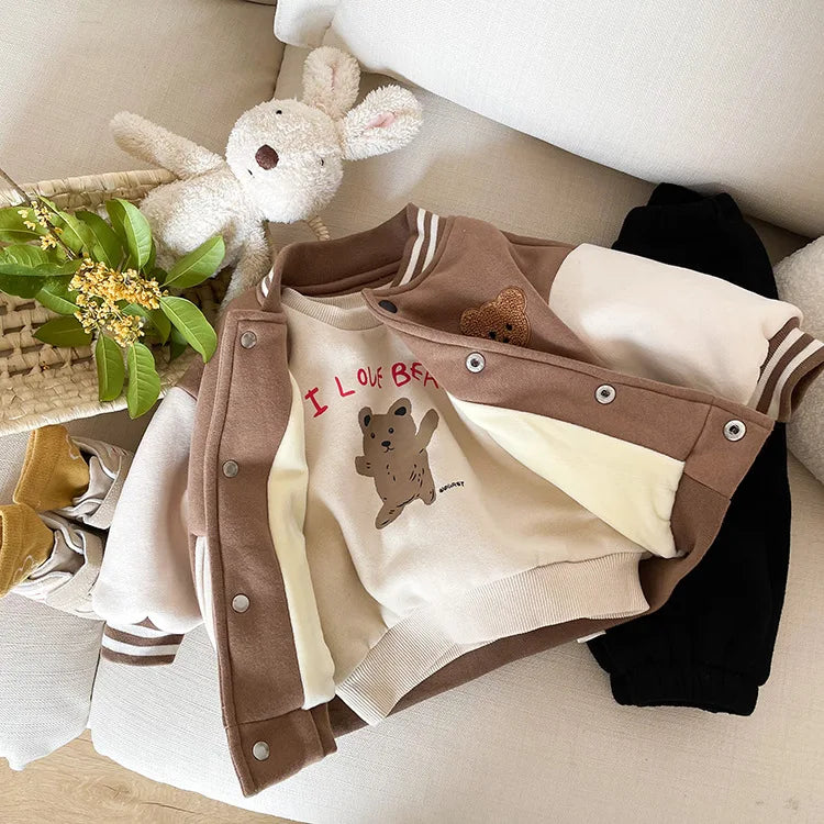 A brown corduroy jacket with light cream lining is shown next to a white stuffed rabbit on a light-colored surface.