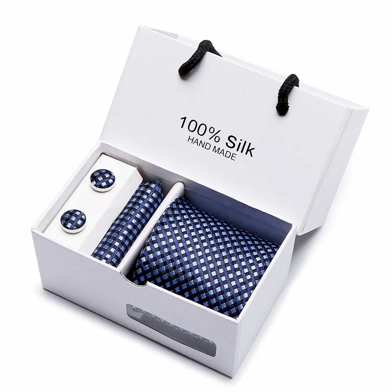 Una caja blanca con una corbata de seda azul marino, hecha a mano con jacquard de paisley.