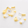 A set of yellow and white striped cotton baby socks displayed on a white background.