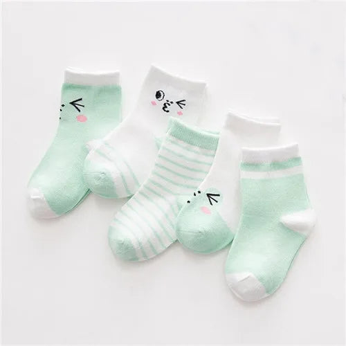 A set of light green and white striped cotton baby socks with cute face designs.