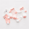 A set of five pink and white striped cotton baby socks laid out on a white background.
