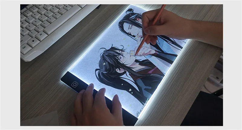 يد ترسم على لوحة رسم A4 LED بقلم ضوئي تحت ضوء ساطع.