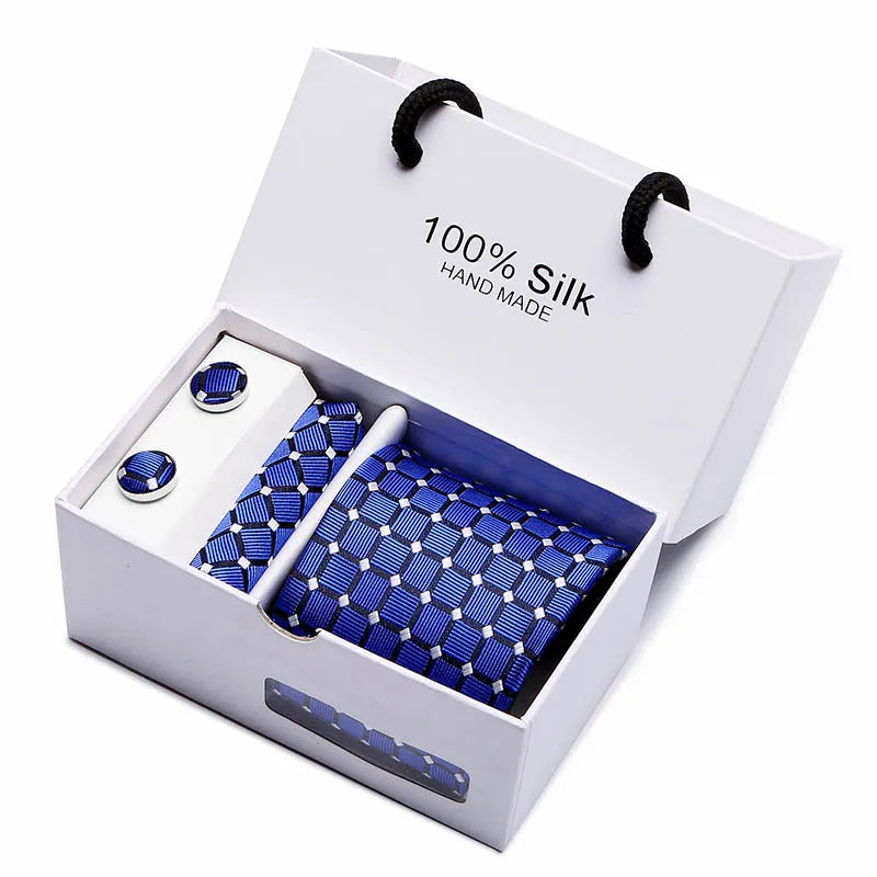 Corbata de seda azul marino tejida a mano con estampado paisley en una caja blanca.