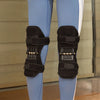 A pair of black spring-assisted knee support braces worn on the lower legs of a person.